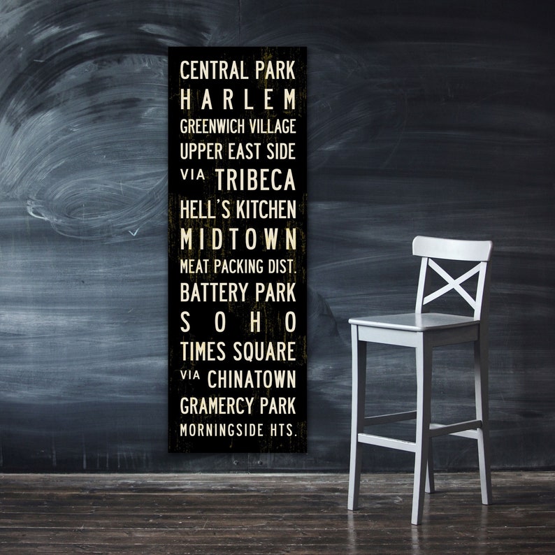 NEW YORK Subway Sign Art from Transit Design. A black and white sign with the names of different neighborhoods in New York City, including Central Park, Harlem, Greenwich Village, Upper East Side, Tribeca, and Hell's Kitchen among others.