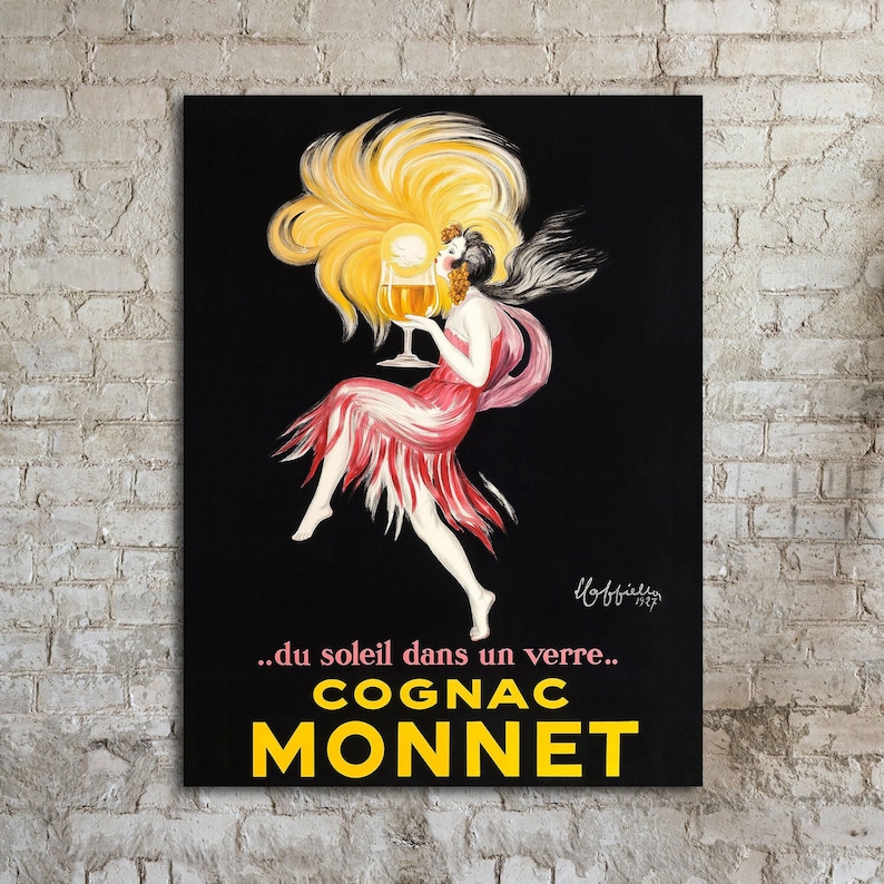 Vintage Advertising Poster for Cognac Monnet from Transit Design. The poster features a woman in a red dress with yellow hair, holding a glass of cognac. The text on the poster reads '...du soleil dans un verre... COGNAC MONNET'. The poster has a black background.