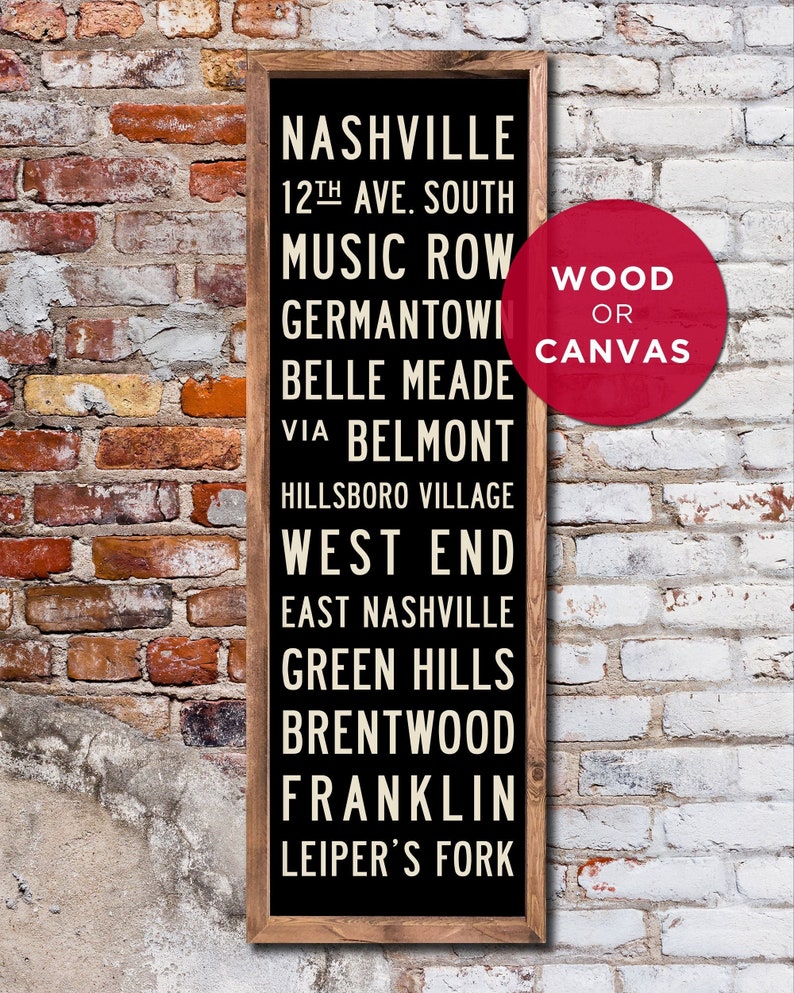 May include: Black sign with white text listing Nashville neighborhoods, including Music Row, Germantown, Belle Meade, and West End. The sign is framed in wood and has a red circle with the text "WOOD OR CANVAS" in white.