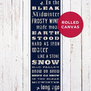 May include: A navy blue rolled canvas print with white text. The text reads "In the Bleak Midwinter" and other lines from the poem. A red circle with the words "ROLLED CANVAS" is on the right side.