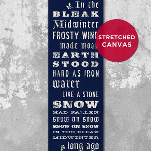 May include: A navy blue stretched canvas wall art print with white text. The text reads "In the Bleak Midwinter" and other lines from the poem. A red circle with "Stretched Canvas" is in the corner.
