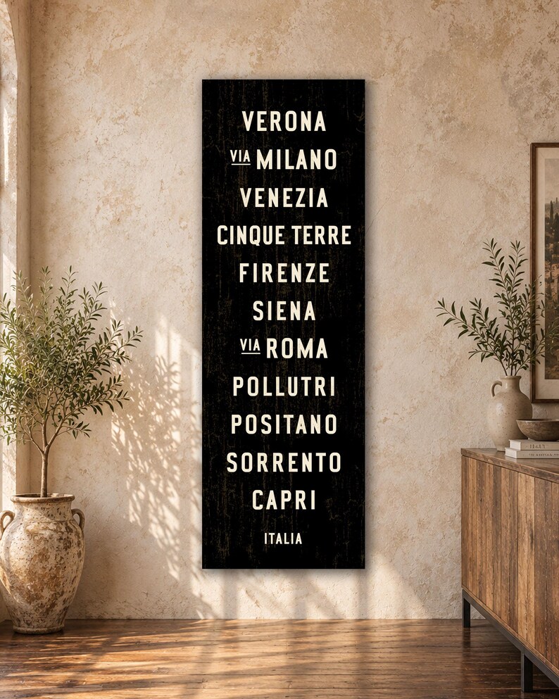 Pu&ograve; includere: Un cartello da parete nero, alto e rettangolare, con testo bianco che elenca citt&agrave; italiane tra cui Verona, Milano, Venezia, Cinque Terre, Firenze, Siena, Roma, Pollutri, Positano, Sorrento e Capri, con la parola ITALIA in basso.