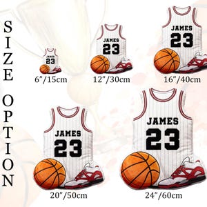 May include: A white basketball jersey with the name "JAMES" and the number "23" is displayed with a basketball and a pair of red and white sneakers. The image shows size options from 6 inches to 24 inches.