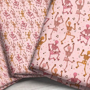 three different fabric print scales featuring a dancing skeleton pattern in pinks and oranges, accented with brown music notes and colorful dots, on a light pink background.