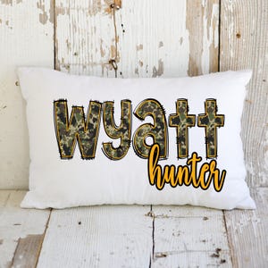 May include: White pillow with the name Wyatt in camouflage print and the word hunter in yellow lettering.