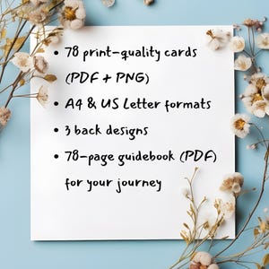 May include: A white rectangular card with black text listing product features: 78 print-quality cards, A4 & US Letter formats, 3 back designs, and a 78-page guidebook. The card is surrounded by dried flowers on a light blue background.