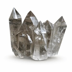 May include: A cluster of smoky quartz crystals, displaying various translucent grey hues. The crystals are sharply pointed, with a natural, unpolished look. The arrangement suggests a geode or natural formation, suitable for collectors or decorative purposes.