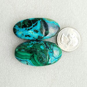 Op de afbeelding: Twee ovale turquoise en groene edelsteen cabochons. De stenen zijn ongeveer zo groot als een Amerikaanse kwart.