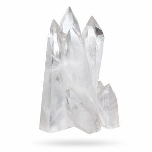 May include: A cluster of clear quartz crystals with sharp, pointed tips. The crystals are transparent, allowing light to pass through, and are arranged in a natural, clustered formation. The quartz has a slightly frosted appearance.