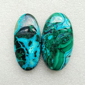 Op de afbeelding: Twee ovale groene en blauwe edelsteen cabochons met een marmerpatroon.