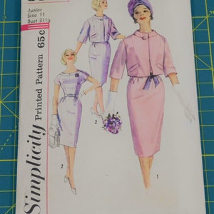 Puede incluir: Patrón de costura impreso Simplicity 3850, talla junior 11, busto 31 1/2, 65c. Un patrón de costura vintage que presenta a dos mujeres con vestidos y chaquetas. Una mujer lleva un vestido y una chaqueta rosas con una cinta morada. La otra mujer lleva un vestido y una chaqueta morados. Ambas mujeres llevan guantes blancos y tienen el pelo peinado en un bouffant.