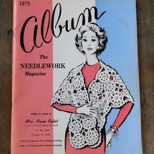 May include: Vintage 1975 "Album" magazine cover. The cover features a woman in a red dress and a white crocheted shawl. The magazine title is in a script font, with the words "The Needlework Magazine" below.