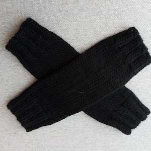 May include: A pair of black knitted fingerless gloves. The gloves are made of a soft, warm material and are perfect for keeping your hands warm in the winter.