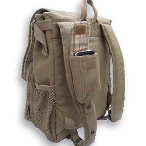 Peut inclure: Sac &agrave; dos en toile beige avec plusieurs poches et un motif &agrave; carreaux. Il comporte une poche lat&eacute;rale en filet, une poche avant avec rabat et une bandouli&egrave;re avec une poche pour t&eacute;l&eacute;phone. Poign&eacute;e sup&eacute;rieure et bretelles r&eacute;glables.