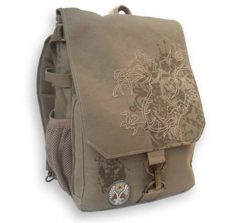 Peut inclure: Un sac &agrave; dos beige avec une fermeture &agrave; rabat et un motif de dragon brod&eacute; sur le devant. Le sac &agrave; dos a une poche lat&eacute;rale en filet, des bretelles r&eacute;glables et un petit &eacute;cusson avec une &eacute;toile et des ailes. Le sac est en mat&eacute;riau durable.