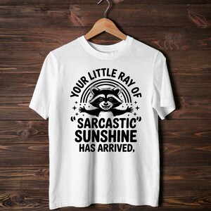 Sarcastic Funny,raccoon quote svg,sarcastic quote svg,Sarcastic Funny SVG,sassy raccoon svg,trendy raccoon svg,your little ray svg,sassy raccoon,sarcastic raccoon,raccoon sarcastic,sublimation raccoon,raccoon quote,sarcastic sunshineYour little ray of sarcastic sunshine svg, Sarcastic svg, Has arrived svg, funny raccoon svg, sassy raccoon , trendy design sublimation PNG
Your Little Ray Of Sarcastic Sunshine Has Arrived SVG PNG, Retro Funny Raccoon Shirt Design, Sarcastic Svg, Sassy Meme