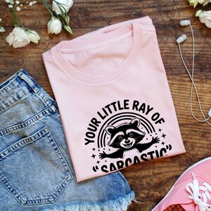 Sarcastic Funny,raccoon quote svg,sarcastic quote svg,Sarcastic Funny SVG,sassy raccoon svg,trendy raccoon svg,your little ray svg,sassy raccoon,sarcastic raccoon,raccoon sarcastic,sublimation raccoon,raccoon quote,sarcastic sunshineYour little ray of sarcastic sunshine svg, Sarcastic svg, Has arrived svg, funny raccoon svg, sassy raccoon , trendy design sublimation PNG
Your Little Ray Of Sarcastic Sunshine Has Arrived SVG PNG, Retro Funny Raccoon Shirt Design, Sarcastic Svg, Sassy Meme