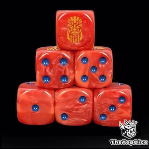 Puede incluir: Seis dados rojos con efecto veteado, apilados sobre un fondo negro. Cada dado tiene puntos azules y un emblema dorado. Los dados están dispuestos en forma de pirámide. Para juegos de mesa.