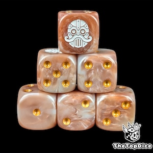 May include: Six dice with a pearlescent, brown and white marbled effect are stacked. One die features a white, stylized face design. The dice have gold-coloured dots for numbers. The dice are stacked on a black background.