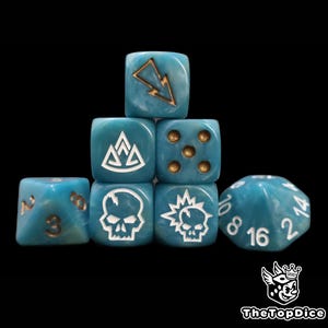 May include: A collection of teal dice with white and gold accents. The dice feature various symbols, including a lightning bolt, a skull, and a crown. The dice are arranged in a pyramid shape against a black background.