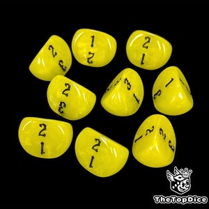 May include: A collection of yellow, semi-translucent dice with black numbering. Each die has three sides, displaying the numbers 1, 2, and 3. The dice are arranged on a black background. The logo "TheTopDice" is in the bottom right corner.