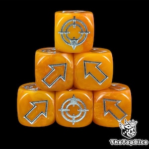 May include: Six orange dice with silver symbols, including arrows and crosshairs, are stacked against a black background. The dice have a marbled appearance. The logo "TheTopDice" is in the bottom right corner.