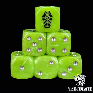 May include: Six green dice stacked in a pyramid formation against a black background. Each die has silver pips and a black symbol on one face. The dice have a marbled appearance.