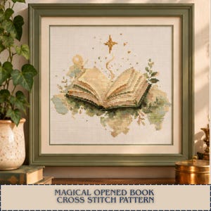 May include: A framed cross-stitch pattern featuring an open book with beige pages, surrounded by soft green foliage and a golden star above. The design is centred on a white fabric background within a sage green wooden frame, showcasing intricate needlework.
