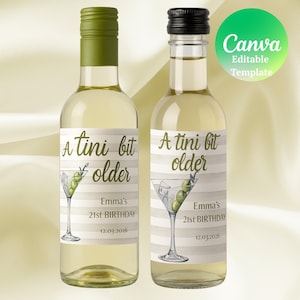 May include: Two small wine bottles with labels that read "A tini bit older" and "Emma's 21st BIRTHDAY 12.03.2026". The labels feature a martini glass with olives. One bottle has a green cap, the other a black cap.