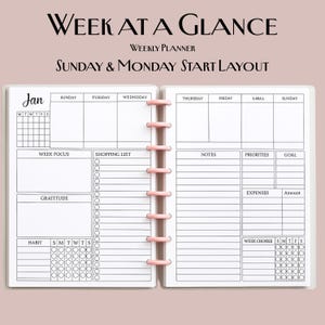 May include: Open weekly planner with a pink binding. The planner is open to a two-page spread with a "Week at a Glance" layout. The left page includes sections for "Week Focus," "Shopping List," "Gratitude," and "Habit." The right page has sections for "Notes," "Priorities," "Goal," and "Expenses."
