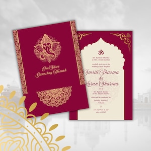 以下が含まれることがあります： 金色のアクセントが付いた、バーガンディ色の結婚式の招待状。招待状にはガネーシャの金のイラストと装飾的なボーダーが描かれています。テキストには名前とイベントの詳細が含まれています。招待状は、内部のテキストを表示するために開いています。