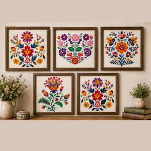 Puede incluir: Cinco cuadros cuadrados de pared con coloridos diseños de bordado floral sobre un fondo de tela clara. Cada marco contiene una disposición simétrica única de flores en tonos rojo, naranja, amarillo, rosa, morado y azul.