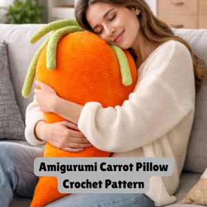 May include: An orange amigurumi carrot pillow with green leafy tops. The pillow is being held by a person. The text on the image says "Amigurumi Carrot Pillow Crochet Pattern".