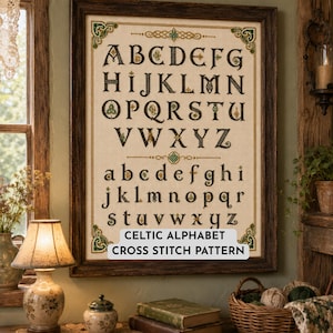 May include: A framed cross-stitch sampler featuring a Celtic-style alphabet with both uppercase and lowercase letters in black, green, and gold thread on a light beige fabric background. The text "CELTIC ALPHABET CROSS STITCH PATTERN" is visible.