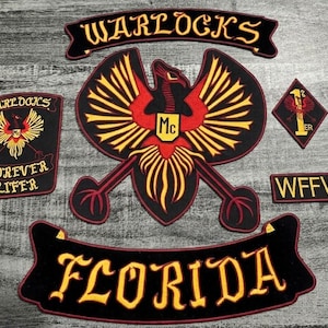 Könnte beinhalten: Eine Sammlung von schwarz-roten gestickten Aufnähern mit gelben Akzenten. Die Aufnäher zeigen die Wörter "WARLOCKS", "FLORIDA", "FOREVER LIFER" und "WFFW". Ein zentraler Aufnäher zeigt ein stilisiertes Adleremblem.