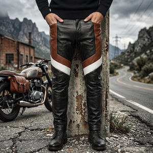May include: Leather pants featuring a color-blocked design with black, brown, and white panels. The pants have a fitted silhouette and are paired with black leather boots. The design includes distinct geometric sections of leather.