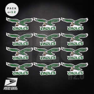 May include: A pack of 12 Philadelphia Eagles stickers. Each sticker features a green eagle with outstretched wings above the word "EAGLES" in white. The United States Postal Service logo is visible.