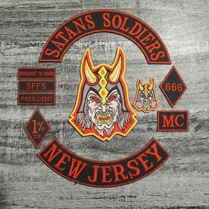 Könnte beinhalten: Eine Sammlung von aufgestickten Aufnähern mit Biker-Motiven. Die Aufnäher zeigen ein teuflisches Gesicht, den Text "SATANS SOLDIERS" und "NEW JERSEY" sowie weitere Symbole in Rot, Schwarz und Gelb.