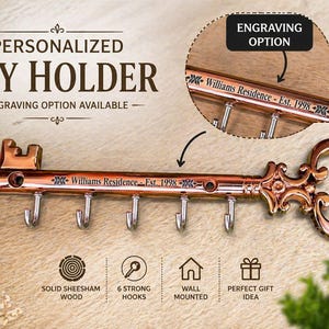 May include: A copper-colored key-shaped key holder with six hooks. The key holder has the text "Williams Residence - Est. 1998" engraved on it. The key holder is wall-mounted and made of solid sheesham wood.