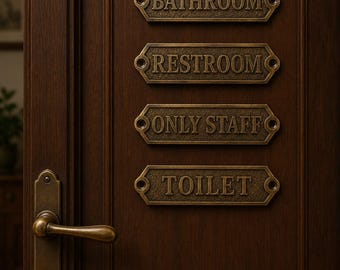 Op de afbeelding: Een donkerbruine houten deur met een messing deurklink en vier rechthoekige messing plaatjes met afgeschuinde randen. De plaatjes zijn gegraveerd met de woorden BATHROOM, RESTROOM, ONLY STAFF en TOILET in een klassiek schreeflettertype.