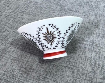 Cuenco de arroz asiático vintage de porcelana blanca con diseño en rojo, negro y dorado.