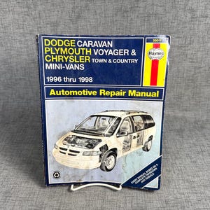 May include: A Haynes automotive repair manual for 1996 thru 1998 Dodge Caravan, Plymouth Voyager, and Chrysler Town & Country mini-vans. The blue cover features a technical illustration of a mini-van with a visible engine and interior details.