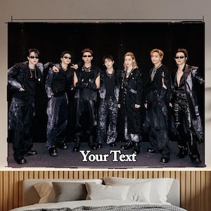 Puede incluir: Un tapiz de pared rectangular que muestra a un grupo de siete personas vestidas con trajes negros y gafas de sol, de pie en fila sobre un fondo negro. El texto "Your Text" está impreso en blanco en la parte inferior central de la imagen.