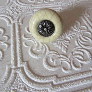 May include: A set of three ceramic mugs with a speckled, matte finish. The mugs are in cream, light grey, and dark grey. Each mug has a simple, minimalist design, ideal for coffee or tea.