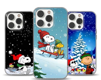 Può includere: Tre custodie per telefono con disegni di Snoopy e Woodstock a tema invernale. Una custodia ha uno sfondo nero con neve che cade e Snoopy con un cappello da Babbo Natale. Un'altra mostra Snoopy e Woodstock che vanno in slitta. La terza ha uno sfondo blu con un albero di Natale.
