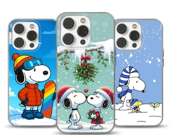 Può includere: Tre custodie per telefono con Snoopy in scene invernali. Una custodia mostra Snoopy che fa snowboard, un'altra mostra Snoopy che si bacia e la terza mostra Snoopy nella neve. Ogni custodia ha un bordo trasparente e un design colorato.