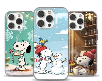 Può includere: Tre custodie per telefono con Snoopy in scene invernali. Una custodia mostra Snoopy che tiene una tazza con un bastoncino di zucchero, un'altra mostra Snoopy che costruisce un pupazzo di neve e la terza mostra Snoopy in un bar.