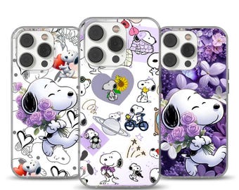 Puede incluir: Tres fundas para teléfono con diseños de Snoopy. Una funda tiene un fondo blanco con Snoopy sosteniendo flores moradas. Otra tiene un fondo morado con Snoopy y varios gráficos. La tercera funda tiene un fondo blanco con Snoopy y corazones.