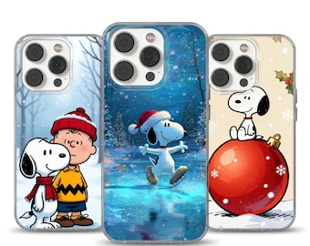 Può includere: Tre custodie per telefono con Snoopy e Charlie Brown in scene invernali. Una custodia mostra Snoopy che pattina sul ghiaccio, un'altra ha Snoopy e Charlie Brown insieme, e la terza Snoopy su una palla di Natale rossa. Le custodie hanno un bordo trasparente.