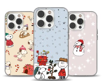 Può includere: Tre custodie per telefono con Snoopy e i personaggi dei Peanuts in scene invernali. Una custodia mostra Snoopy che pattina, un'altra Snoopy con un pupazzo di neve e la terza Snoopy che decora un albero di Natale con Charlie Brown.
